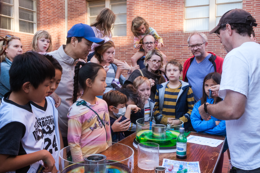 EPSS SpinLab booth at EYU 2022 demonstrates rotating fluid flows to a large audience of children and parents.